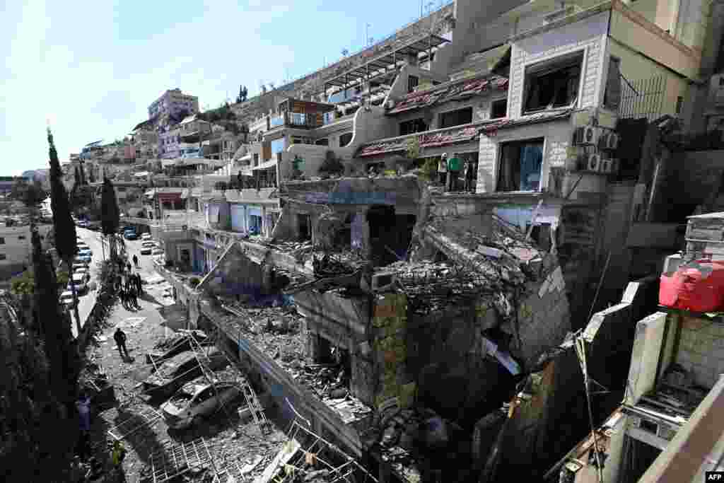 Syrian security forces inspect the site of an Israeli airstrike on a building in Damascus, Syria, in an area where Palestinian leaders are known to reside.