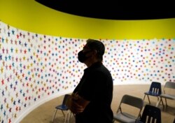 Secretary of the Department of Health and Human Services Xavier Becerra looks at a wall of stars, one each for each child released, at an emergency shelter for migrant children July 2, 2021, in Pomona, Calif.