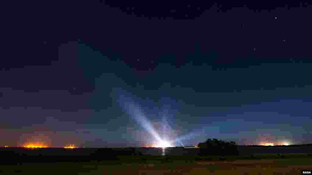 Le vaisseau spatial Orion de la NASA, accroché sur la fusée Launch Alliance Delta IV Heavy, est aperçu au loin, illuminé, dans cette photographie d&#39;exposition prises tôt le jeudi 4 décembre 2014, au complexe de lancement spatial de Base de lancement de Cap Canaveral.