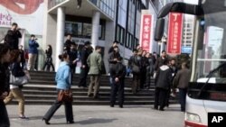 Plainclothes security gather to load detained worshipers of the unregistered Shouwang house church in Beijing, China, April 10, 2011