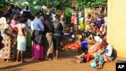 Family members and onlookers mourn over the bodies of civilians killed by The Allied Democratic Forces rebels in Beni, Eastern Congo, Oct 5, 2018.