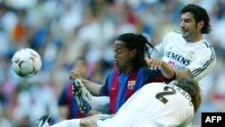 Le Portugais Luis Figo, à droite, et Michel Salgado du Real Madrid aux prises avec le Brésilien Bonaldinho de Barcelone, à gauche, lors de leur match de football de Premier League espagnole au stade Santiago Bernabeu, Madrid, 25 avril 2004.