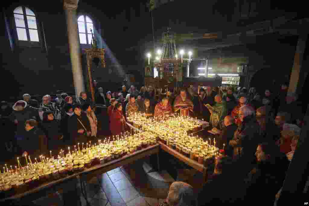 Orthodox priests sing and pray during a mass at the Presentation of the Blessed Virgin church in the town of Blagoevgrad, Bulgaria, marking the the day of St. Haralambos, Orthodox patron saint of bee-keepers.