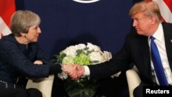 FILE - U.S. President Donald Trump shakes hands with British Prime Minister Theresa May during the World Economic Forum annual meeting in Davos, Switzerland, Jan. 25, 2018.