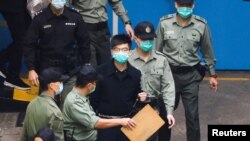 Aktivis pro-demokrasi Joshua Wong berjalan ke van penjara untuk menuju ke pengadilan bersama aktivis lainnya, atas tuduhan hukum keamanan nasional, di Hong Kong, China, 4 Maret 2021. (Foto: REUTERS/Tyrone Siu)