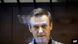 Tokoh oposisi Rusia Alexei Navalny melihat ke arah fotografer ketika menjalani persidangan di pengadilan Distrik Babuskinsky di Moskow, Rusia, pada 20 Februari 2021. (Foto: AP/Alexander Zemlianichenko)