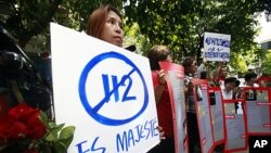 Supporters of Somsak Jeamteerasakul, a 54-year-old professor and former student activist, hold placards at a police station in Bangkok, May 11, 2011. Thailand's army filed charges against the historian for insulting the monarchy, a crime punishable by up 