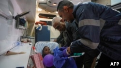 An Egyptian medic assists a young Palestinian patient evacuated from Gaza through the Rafah crossing as the child arrives at al-Arish General Hospital in Egypt's north eastern Sinai province, Feb. 1, 2025.