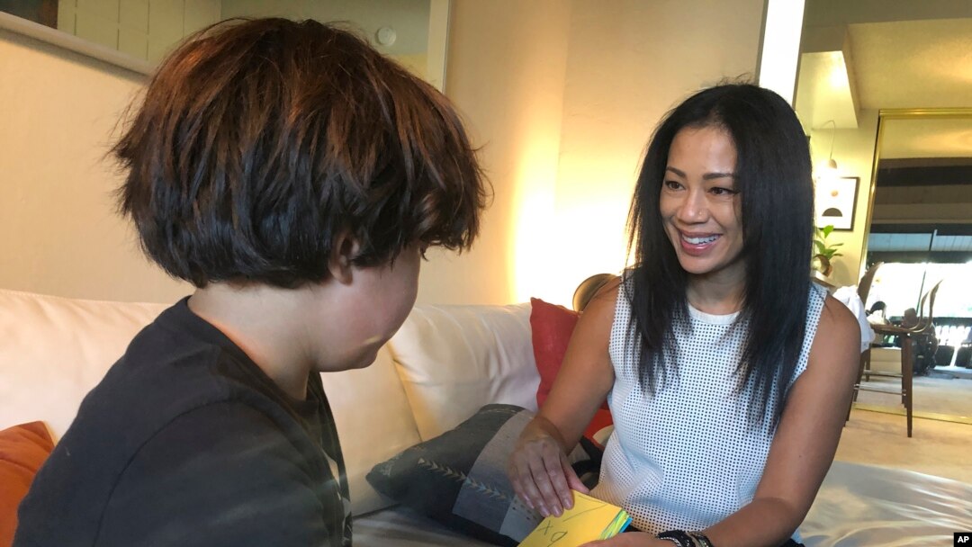 Keryn Francisco di Alameda, California, menggunakan kartu untuk membantu putranya Reve Francisco (10 tahun) belajar matematika, Selasa, 2 November 2021. (AP Photo/Haven Daley)