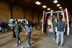 French Gendarmes evacuate the last partygoers who attended a rave in a disused hangar in Lieuron, south of Rennes, Jan. 2, 2021.