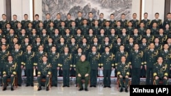 In this photo released by Xinhua News Agency, Chinese President Xi Jinping poses for photos with military personnel of the Chinese People's Liberation Army garrison stationed in the Macao Special Administrative Region in southern China, Dec. 20, 2024. (Li Gang/Xinhua via AP)