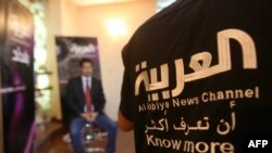 FILE - Staffers of Dubai-based Al-Arabiya TV prepare for an evening news broadcast in Baghdad, Iraq, June 25, 2010.