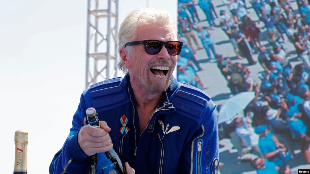 Richard Branson prepares to spray champagne after flying with a crew in Virgin Galactic's passenger rocket plane VSS Unity to the edge of space, at Spaceport America, near Truth or Consequences, New Mexico, July 11, 2021.