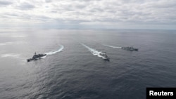 Japan Maritime Self Defense Force's JS Atago (DDG-177), U.S. Navy's USS Barry (DDG 52) and South Korean Navy's Sejong the Great-class destroyer take part in a trilateral exercise in the Sea of Japan, also called East Sea in South Korea, in this handout picture taken by the Japan Self-Defense Force and released Feb. 22, 2023.
