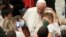 FILE - Pope Francis meets with children assisted by Santa Marta dispensary in the Paul VI Hall, at the Vatican, Dec. 19, 2021. 