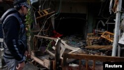 A man looks at the site of a bomb attack at a cafe in Baghdad's al-Bayaa district, Nov. 21, 2013. 