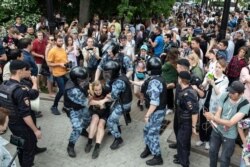 Police officers detain a protester during a march in Moscow, Russia, June 12, 2019.