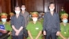 Freelance journalists of the Independent Journalists Association of Vietnam Pham Chi Dung, right, Le Huu Minh Tuan, center, and Nguyen Tuong Thuy stand during their trial Jan. 5, 2021.