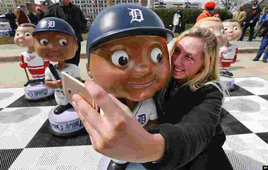 Katie Lanivich takes a photograph with a Detroit Tigers bobble head before a baseball game against the New York Yankees in Detroit, Michigan.