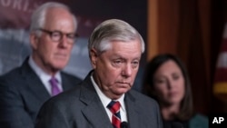 U.S. Senator Lindsey Graham of South Carolina, flanked by Senator John Cornyn of Texas, left, and Senator Katie Britt of Alabama, speaks to reporters as they criticize President Joe Biden's policies on the U.S.-Mexico border, at the Capitol in Washington on Dec. 7, 2023.