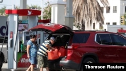 12일 미국 플로리다주 탬파의 주유소 이용자가 기름통 여러 개에 담은 연료를 차량 적재함에 싣고 있다. 