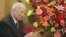 Then Cambodian King Norodom Sihanouk stands beside flowers given by the Chinese government during a meeting with Chinese State Councilor Dai Bingguo (not seen) in Beijing, October 30, 2006.