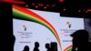 FILE - Delegates are silhouetted against the stage background before British Prime Minister Boris Johnson delivers a speech during the Opening Plenary session of the UK Africa Investment Summit in London, Jan. 20, 2020. 