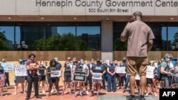 Para pengunjuk rasa berdemo di luar gedung Hennepin county Government Center, sebelum persidangan Derek Chauvin, mantan polisi yang terkait kasus kematian pria kulit hitam, George Floyd, 8 Juni 2020 di Minneapolis, Minnesota.