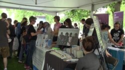 One Journey festival attendees drop by a tent to gather information that was set up by one of many participating non-profit organizations that help refugees.