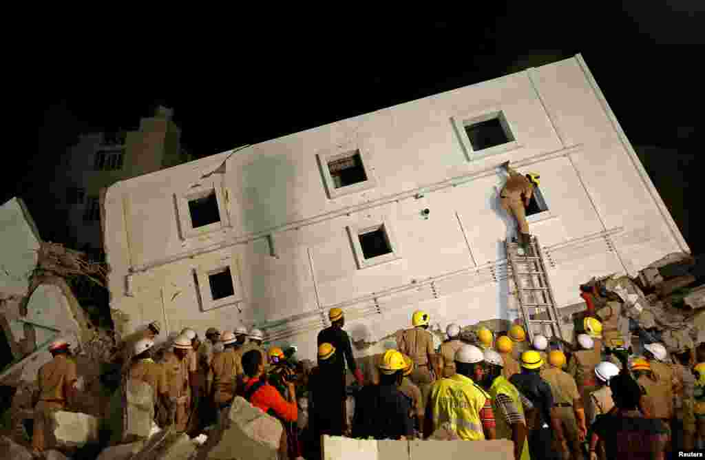 Police and rescue workers look for survivors amidst the rubble at the site of a collapsed under construction building in Bengaluru, India.