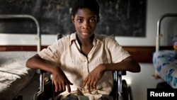 FILE - Marie-Madelaine Avouzoa, whose legs were amputated at the knees and lost her fingertips after a blood transfusion for malaria infected her limbs, sits in a wheelchair at the Center for the Rehabilitation of the Handicapped in Cameroon's capital, Yaounde on March 16, 2009.