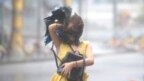 Một người phụ nữ đi trong mưa bão khi Mangkhut ập vào Trung Quốc hôm 16/9.