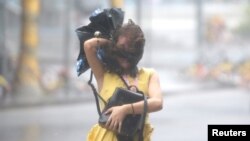 태풍 망쿳이 상륙한 중국 남부에서 한 여성이 폭풍우가 몰아치는 길을 걷고 있다.