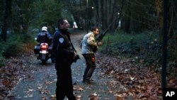 Members of the police animal brigade walk through a wood in Montevrain, east of Paris, Thursday Nov. 13, 2014. 