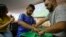 Brazil soccer fan Carlos Junior, who is both deaf and blind, experiences the World Cup match between Brazil and Mexico with the help of an interpreter who uses tactile signing and a model soccer field in Sao Paulo, Brazil, July 2, 2018. Brazil won the match 2-0.