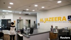 FILE - An employee walks inside an office of Qatar-based Al-Jazeera network in Jerusalem, June 13, 2017.