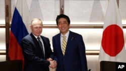 Perdana Menteri Jepang Shinzo Abe (kanan) dan Presiden Rusia Vladimir Putin di Tokyo, Jumat (16/12).