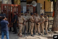 Personel kepolisian Mumbai berjaga di luar kediaman Baba Siddique, seorang politikus senior, yang ditembak di luar kantor putranya di Mumbai dan kemudian meninggal karena luka-lukanya di rumah sakit pada Sabtu malam, di Mumbai, India, 13 Oktober 2024. (Foto: AP)