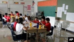 Students in a darkened, fan cooled classroom at Theodore Potter School 74 in Indianapolis, Thursday, Aug. 12, 2010. (AP Photo/Michael Conroy)