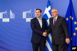 FILE - European Commission President Jean-Claude Juncker, right, welcomes Greece's PM Alexis Tsipras upon his arrival at the European Commission headquarters in Brussels, Feb. 4, 2015.