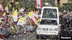 Warga Katolik Lebanon melambaikan bendera Lebanon dan Vatikan saat mobil Paus Benediktus melewati jalan di Beirut (15/9).