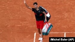 Novak Đoković pozdravlja publiku dok odlazi s terena posle poraza od Italijana Marka čekinata u četvrtfinalu Rolan Garosa (Foto: AP/Michel Euler)