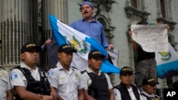 FILE - People protest against a decision by Guatemala's President Jimmy Morales to shut down the United Nations International Commission Against Impunity, CICIG, at Constitution Square in Guatemala City, Sept. 1, 2018. 