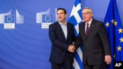 European Commission President Jean-Claude Juncker, right, welcomes Greece's Prime Minister Alexis Tsipras upon his arrival at the European Commission headquarters in Brussels, Feb. 4, 2015. 