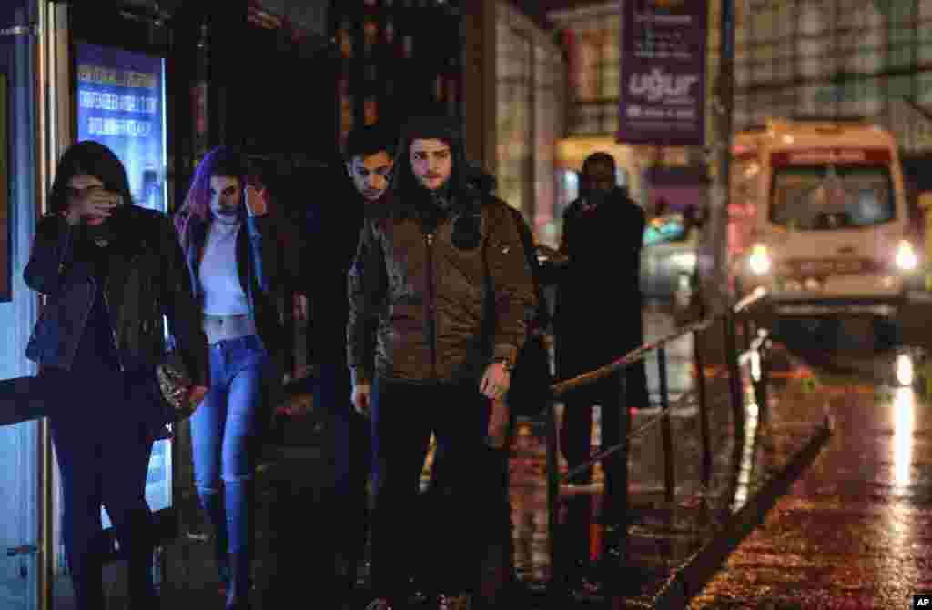 Young people leave the scene of an attack in Istanbul, early Jan. 1, 2017. Turkey's state-run news agency said an armed assailant has opened fire at a nightclub in Istanbul's Ortakoy district.