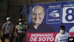Supporters of Avanza Pais party presidential candidate Hernando De Soto listen to his speech next to a billboard with his image as he campaigns at the Caqueta market in Lima, Peru, April 5, 2021.