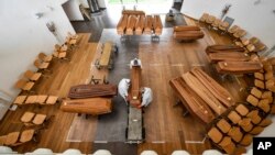 Coffins of coronavirus victims arrive from the Bergamo area, where they are unloaded from a military truck that transported them in the cemetery of Cinisello Balsamo, near Milan in northern Italy.