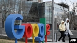 Sejumlah warga tampak berjalan melewati logo Google di luar kantor perusahaan teknologi tersebut di Beijing pada 4 Februari 2025. (Foto: AFP/Greg Baker)