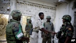 AMISOM commander, Major General Natham Mugisha (R) shakes hands with a commander from the Transitional Federal Government army a day after heavy fighting against the Al Shabaab insurgents in the Sigaale District of Mogadishu, 15 Dec 2010