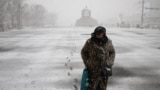 A woman makes her way through heavy snow fall at Gyeongbok palace in central Seoul, South Korea, Feb. 6, 2025. 